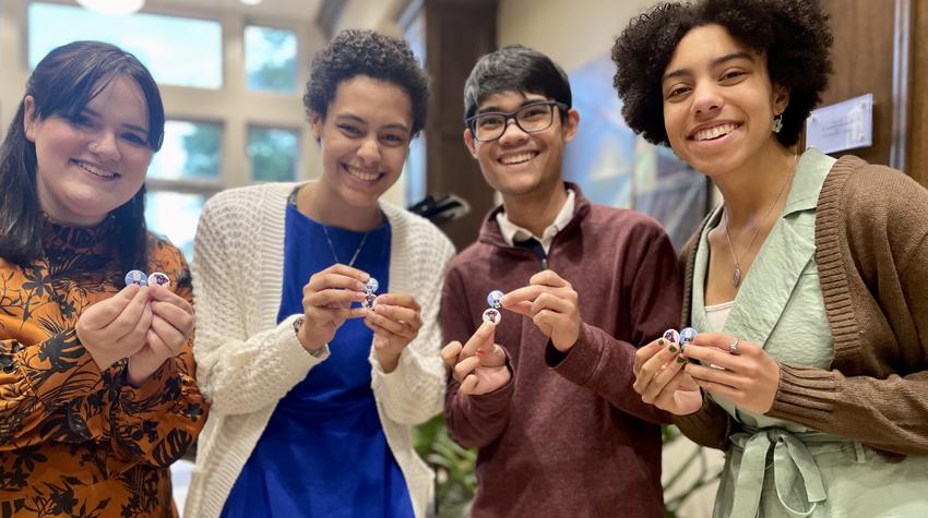 Four students holding buttons given to them by 总统 Bonner.