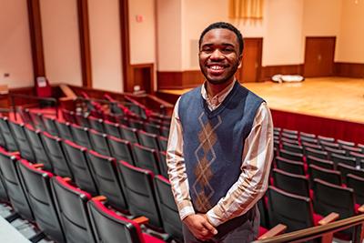 Student smiling in between rows of theatre.